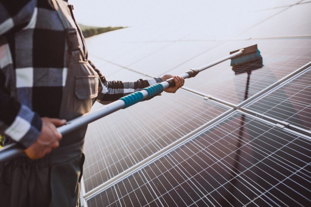 Pulizia pannelli fotovoltaici: uomo che pulisce pannello