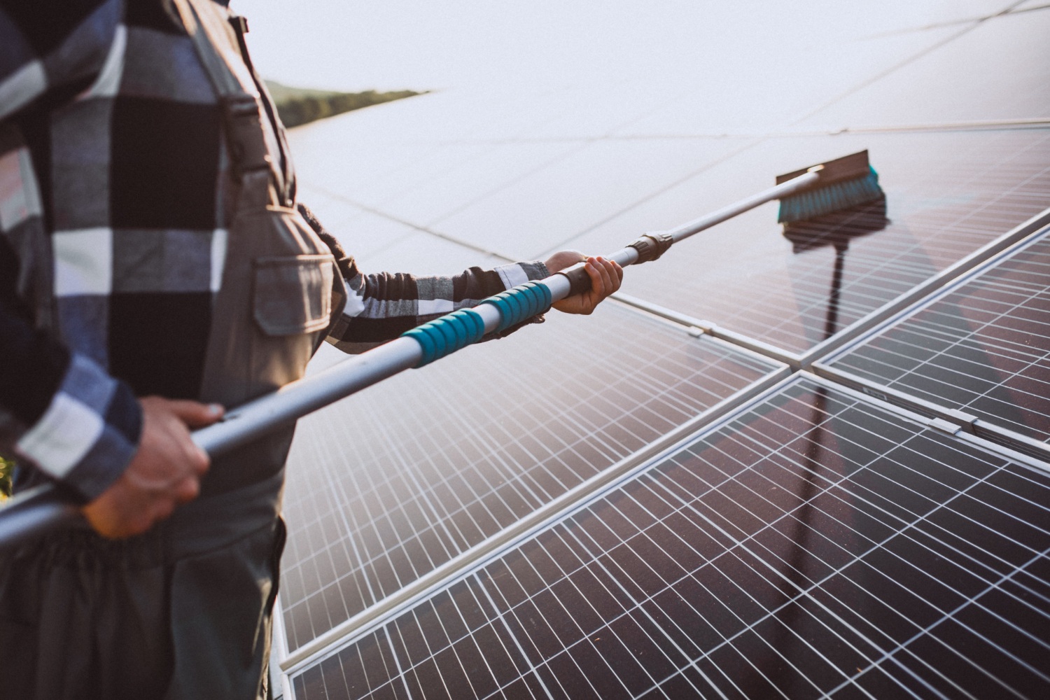 Pulizia pannelli fotovoltaici: uomo che pulisce pannello